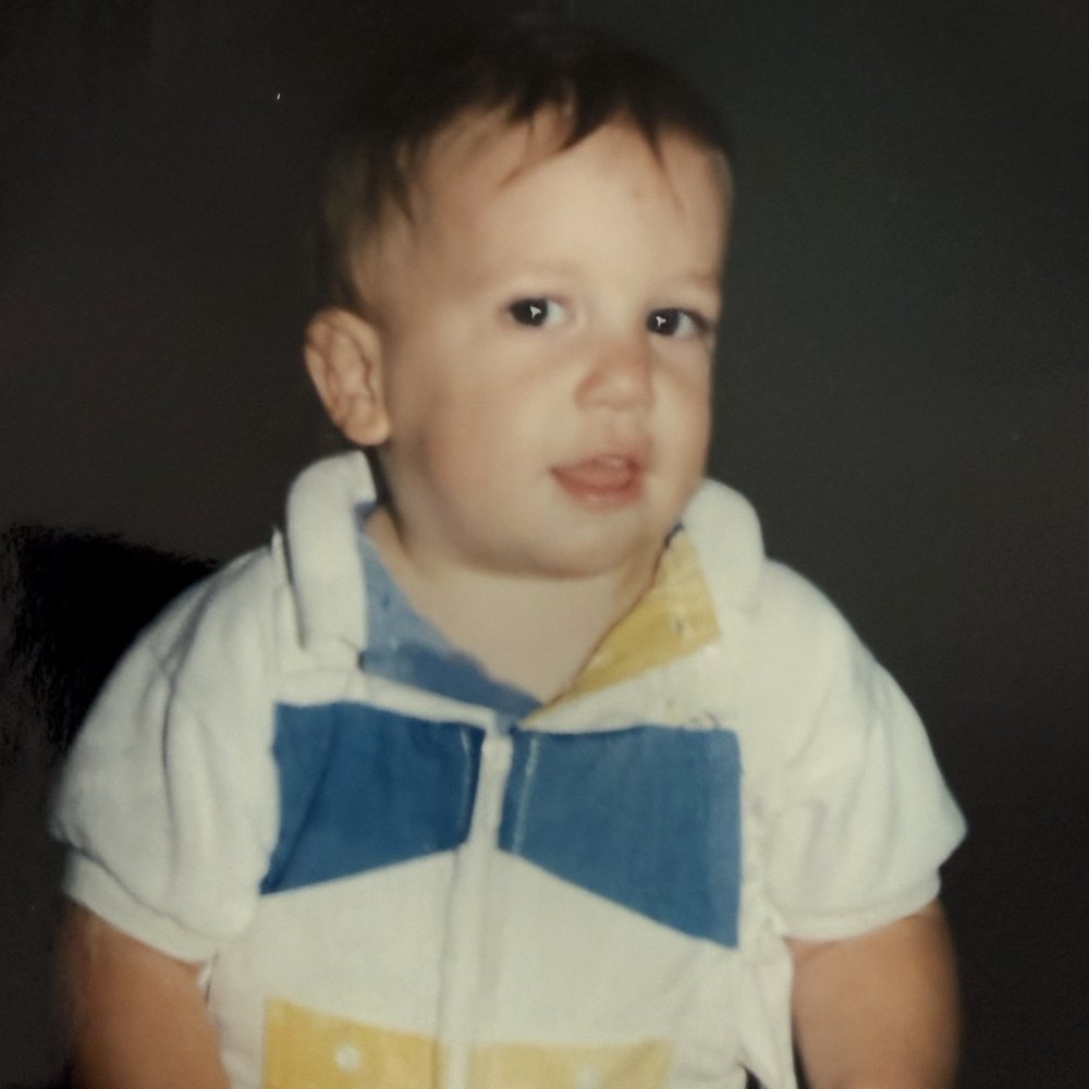 James as a toddler in a white collared shirt